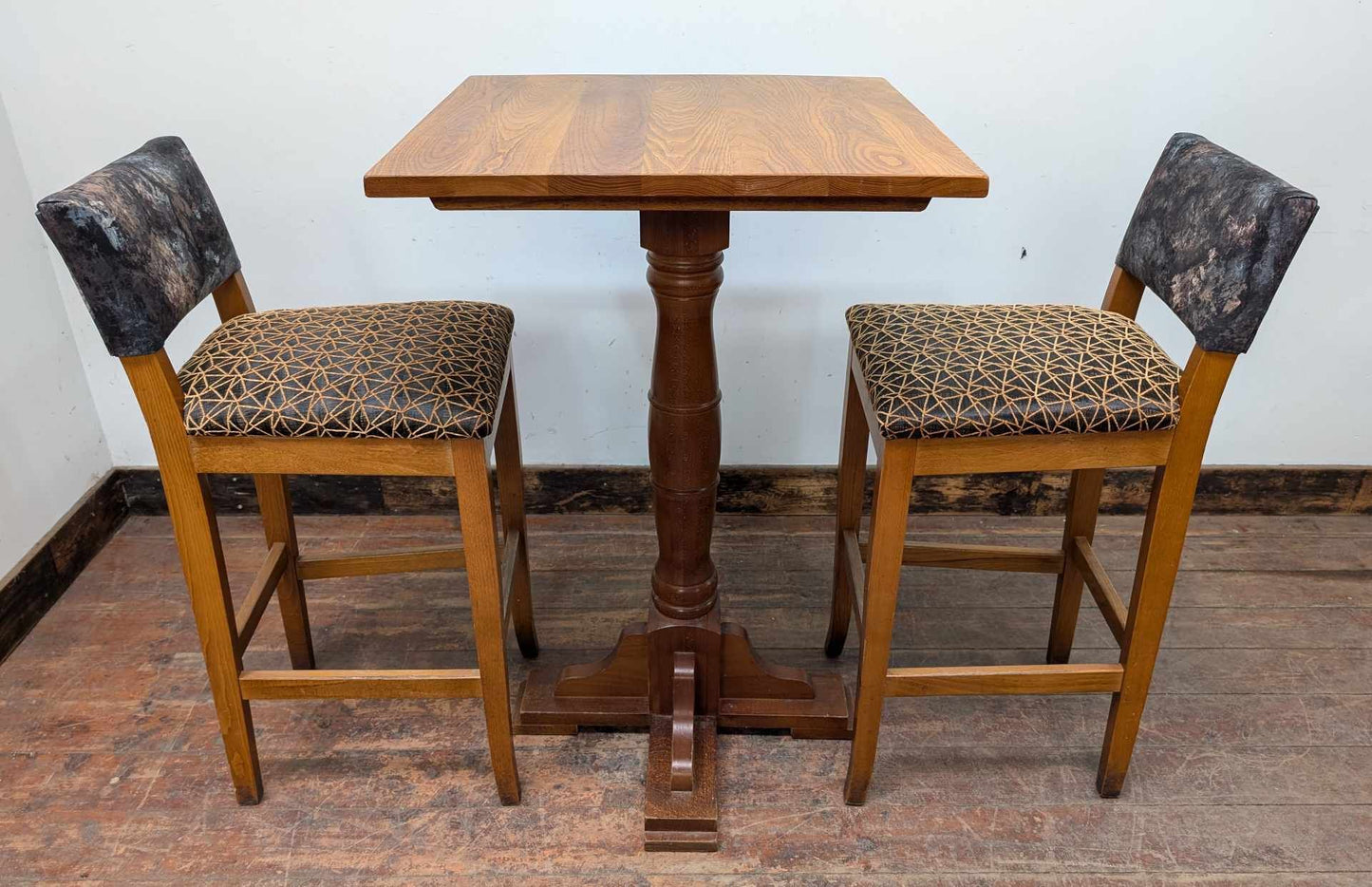 Tall Square Poseur Table with Two Patterned Bar Stools and Light Wood Finish