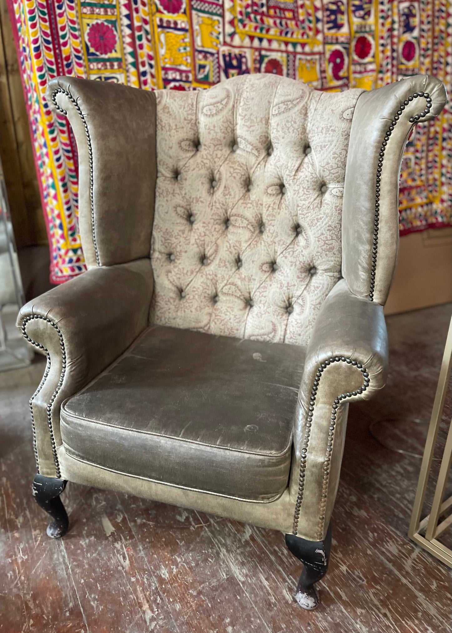 Grey wingback armchair with patterned fabric backrest