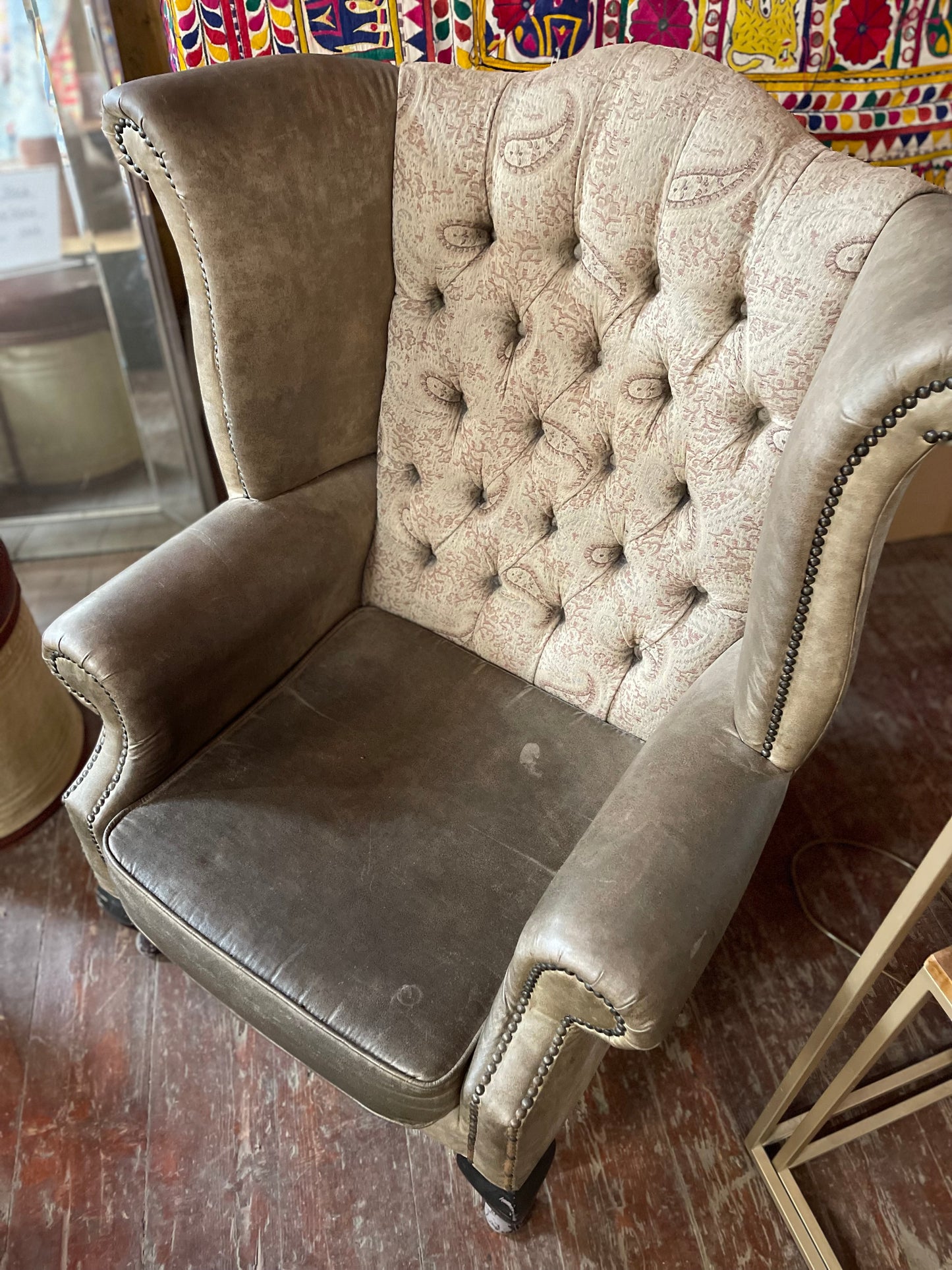 Grey wingback armchair with patterned fabric backrest
