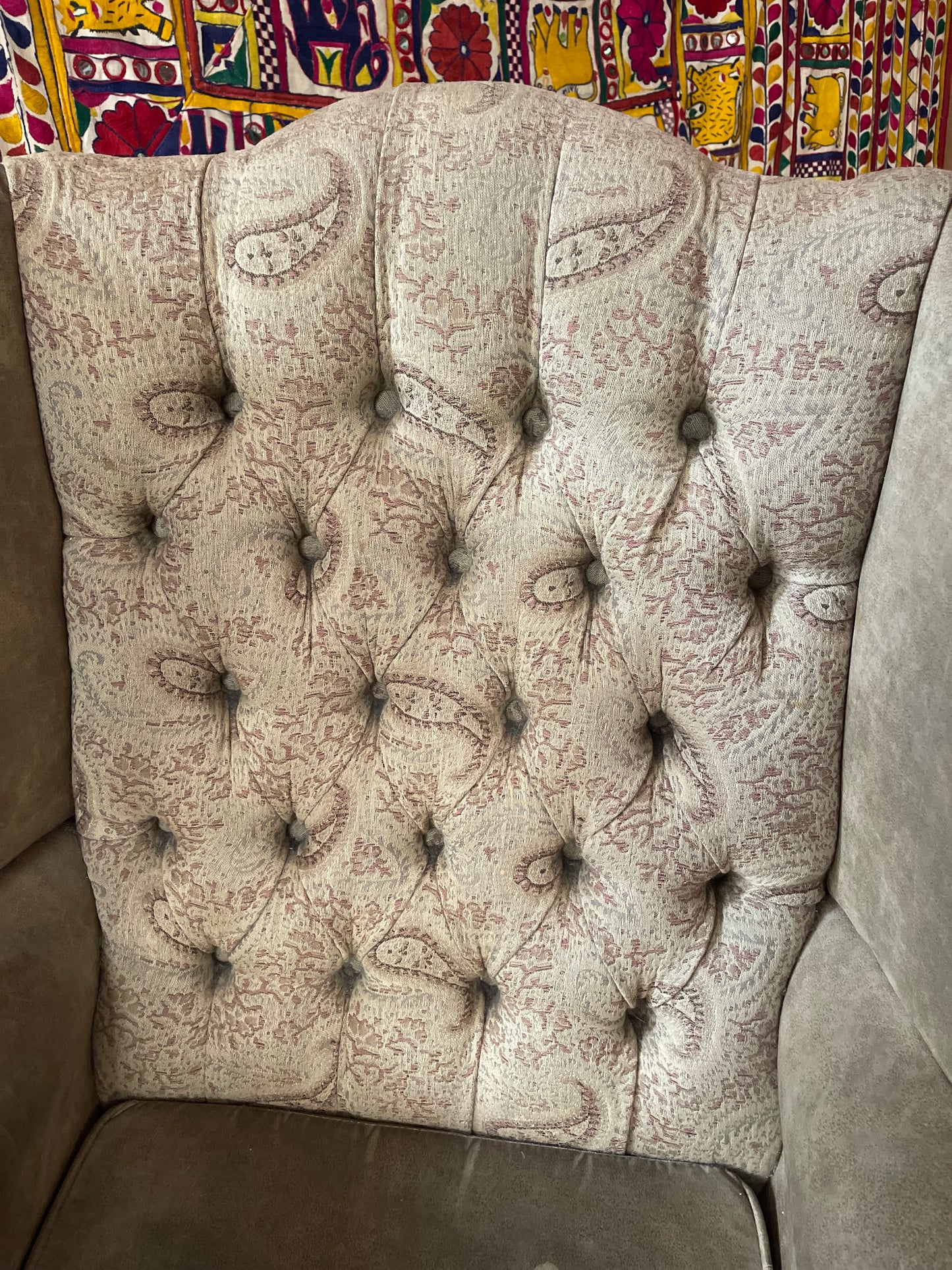 Grey wingback armchair with patterned fabric backrest