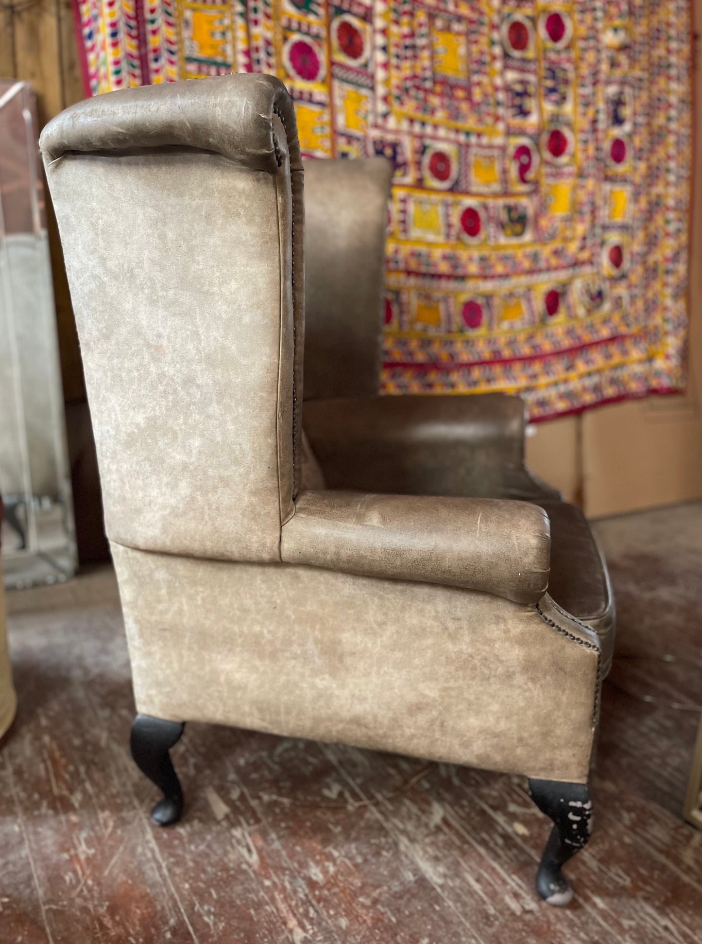 Grey wingback armchair with patterned fabric backrest