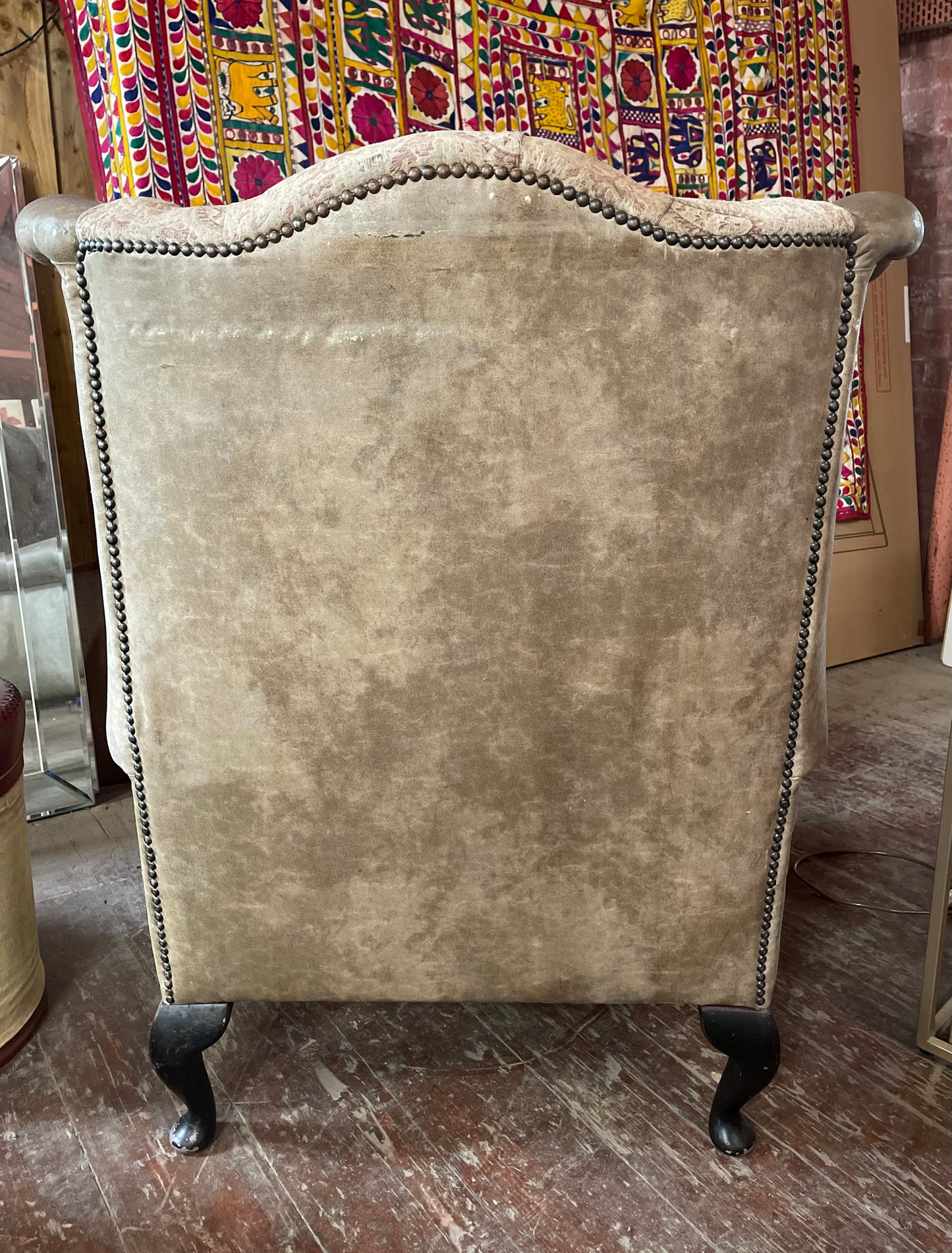 Grey wingback armchair with patterned fabric backrest