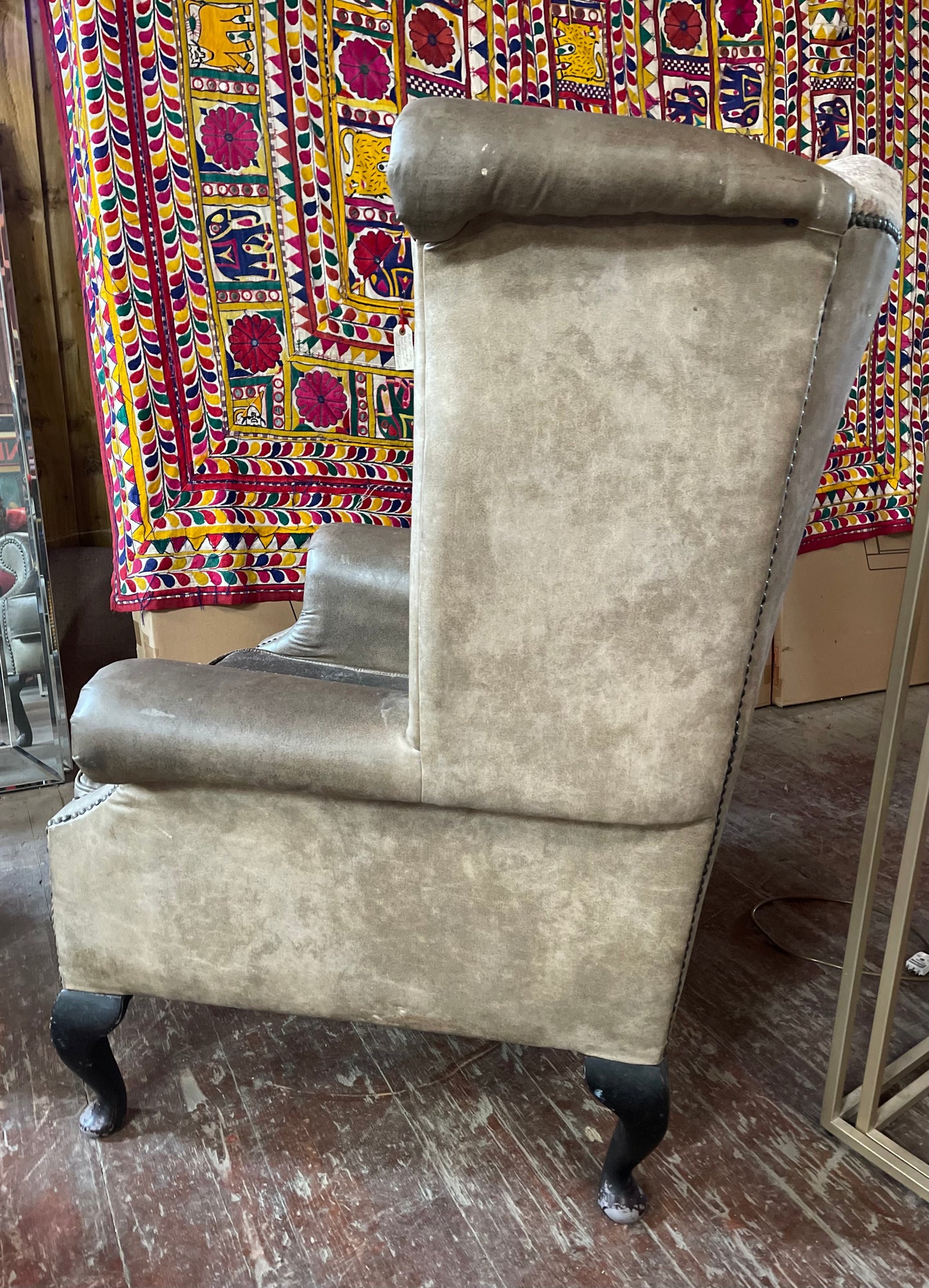 Grey wingback armchair with patterned fabric backrest