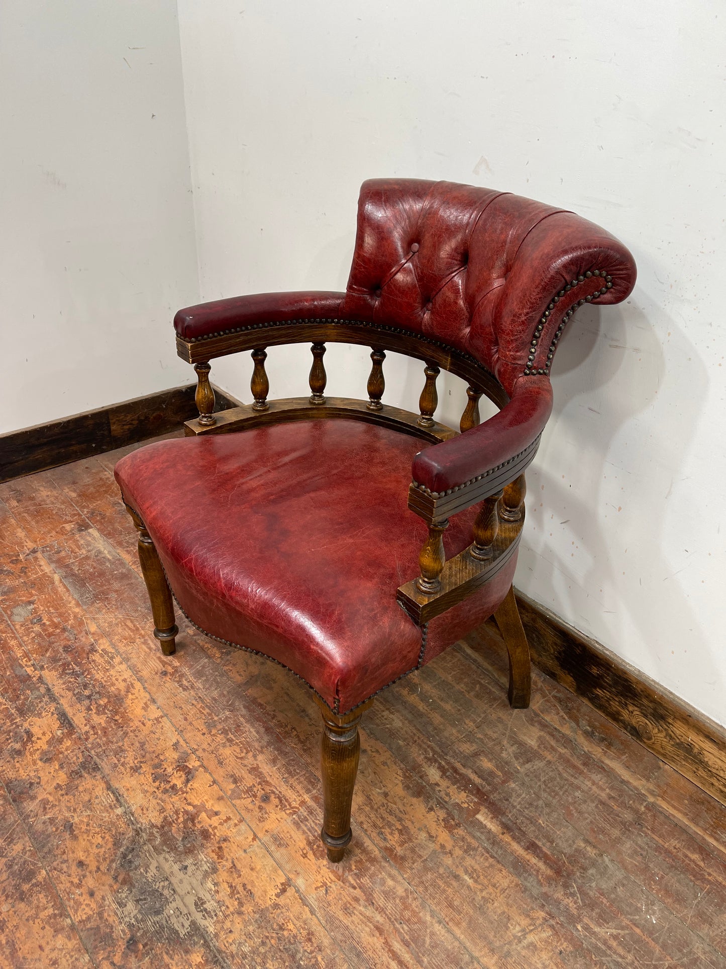 Stunning red leather captain's chair with wooden spindle back