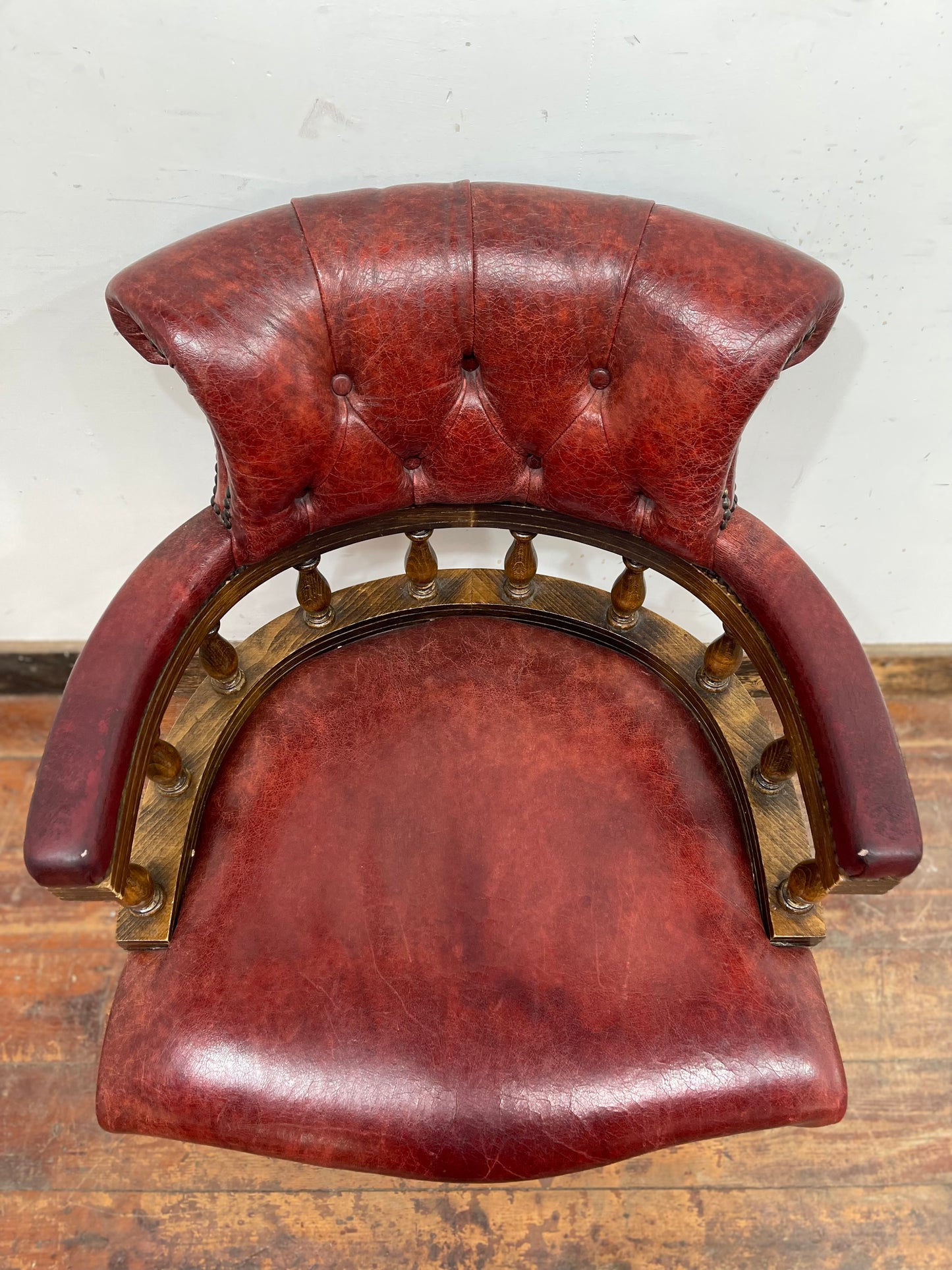 Stunning red leather captain's chair with wooden spindle back