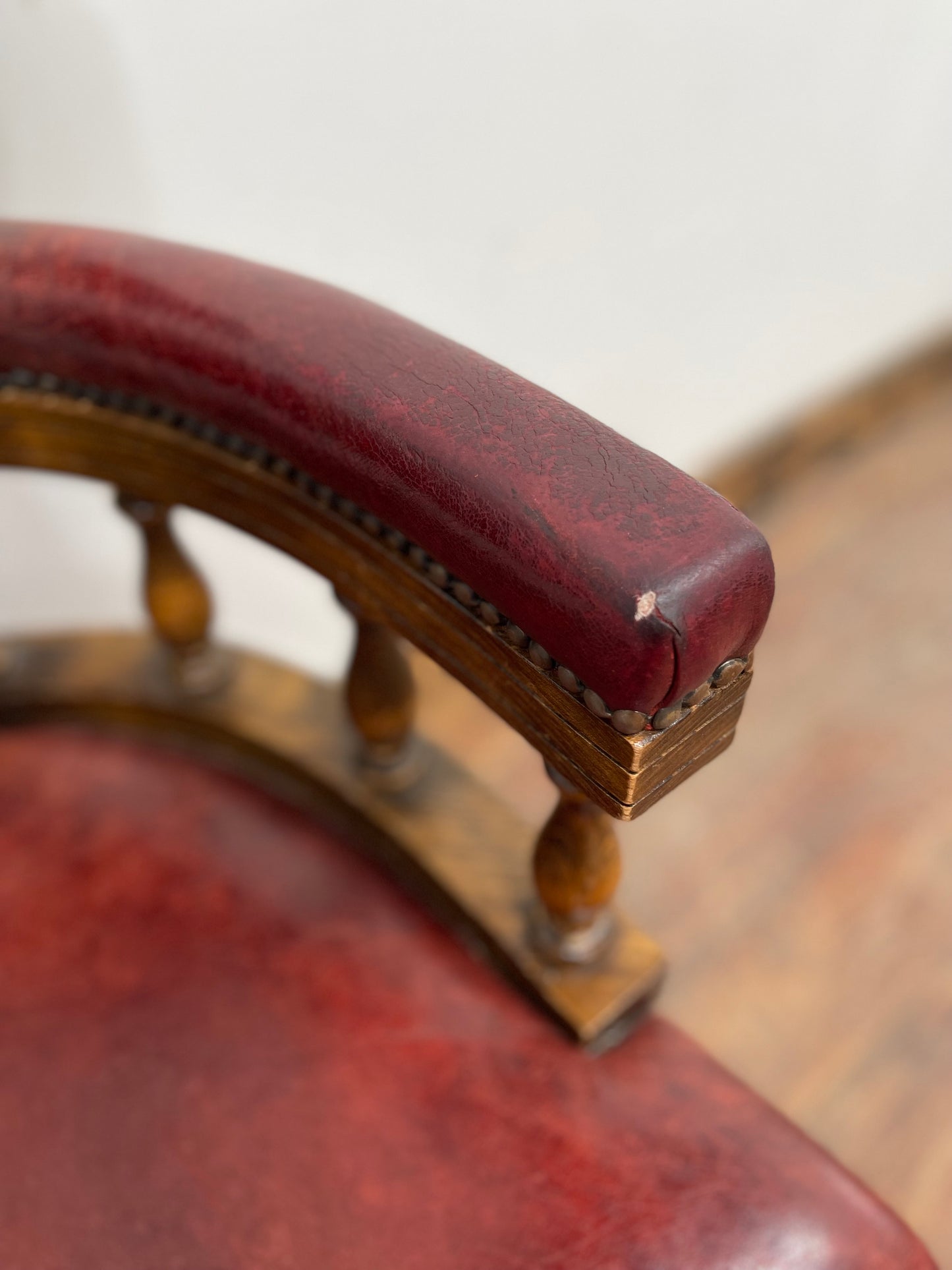Stunning red leather captain's chair with wooden spindle back