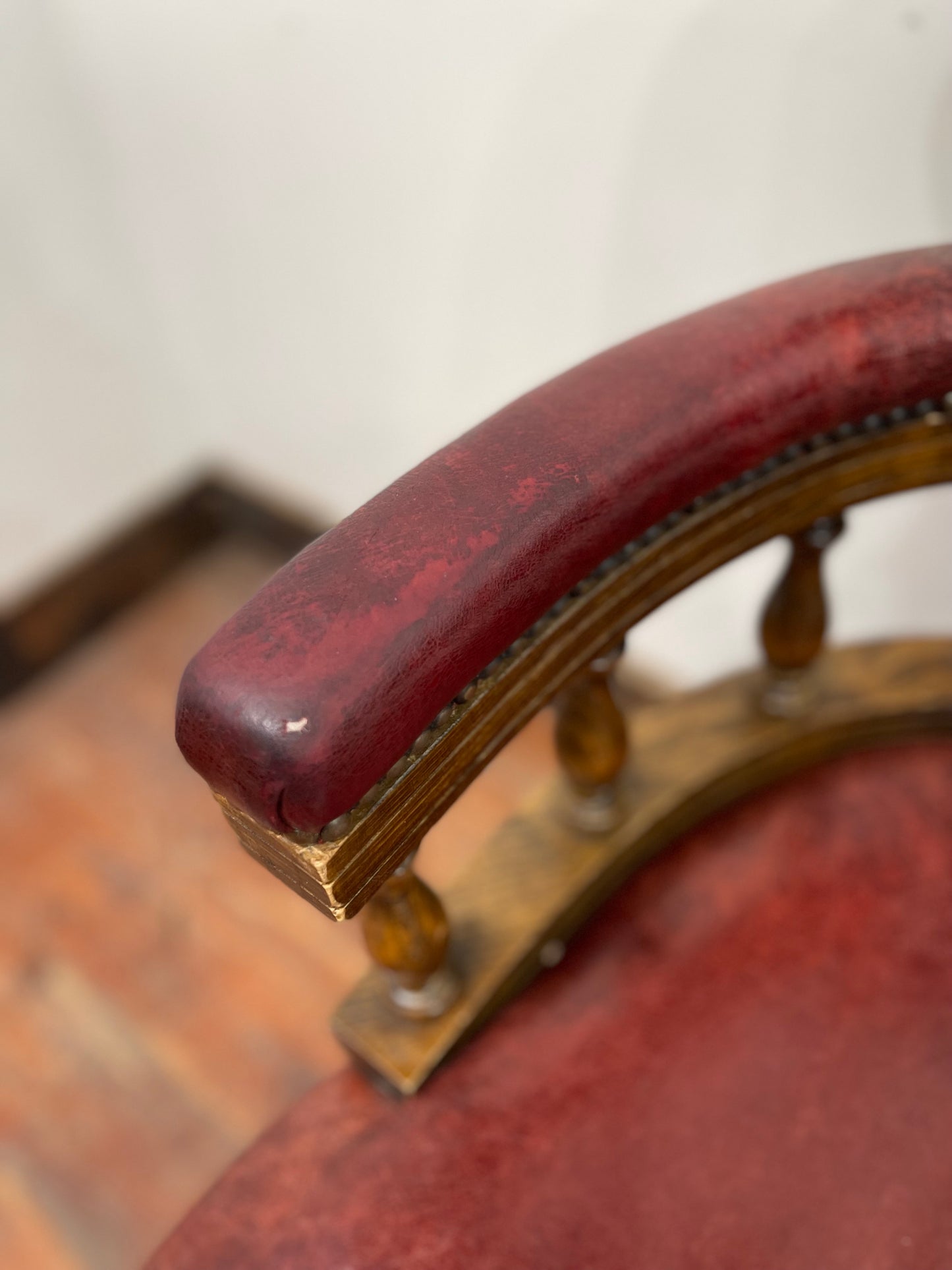Stunning red leather captain's chair with wooden spindle back