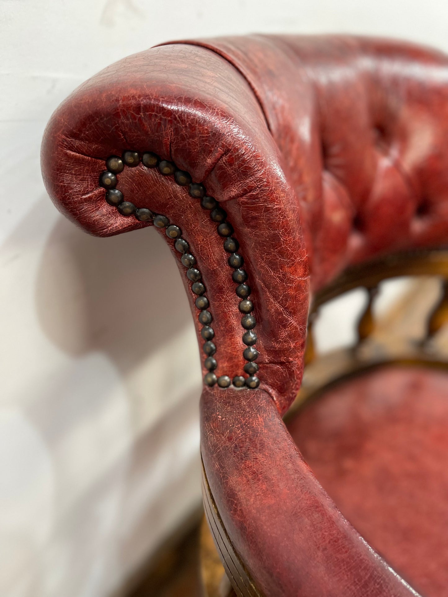 Stunning red leather captain's chair with wooden spindle back