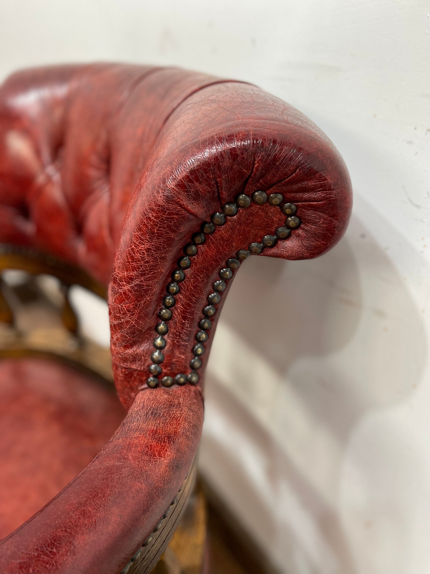 Stunning red leather captain's chair with wooden spindle back