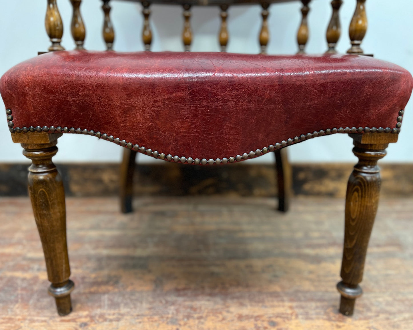 Stunning red leather captain's chair with wooden spindle back