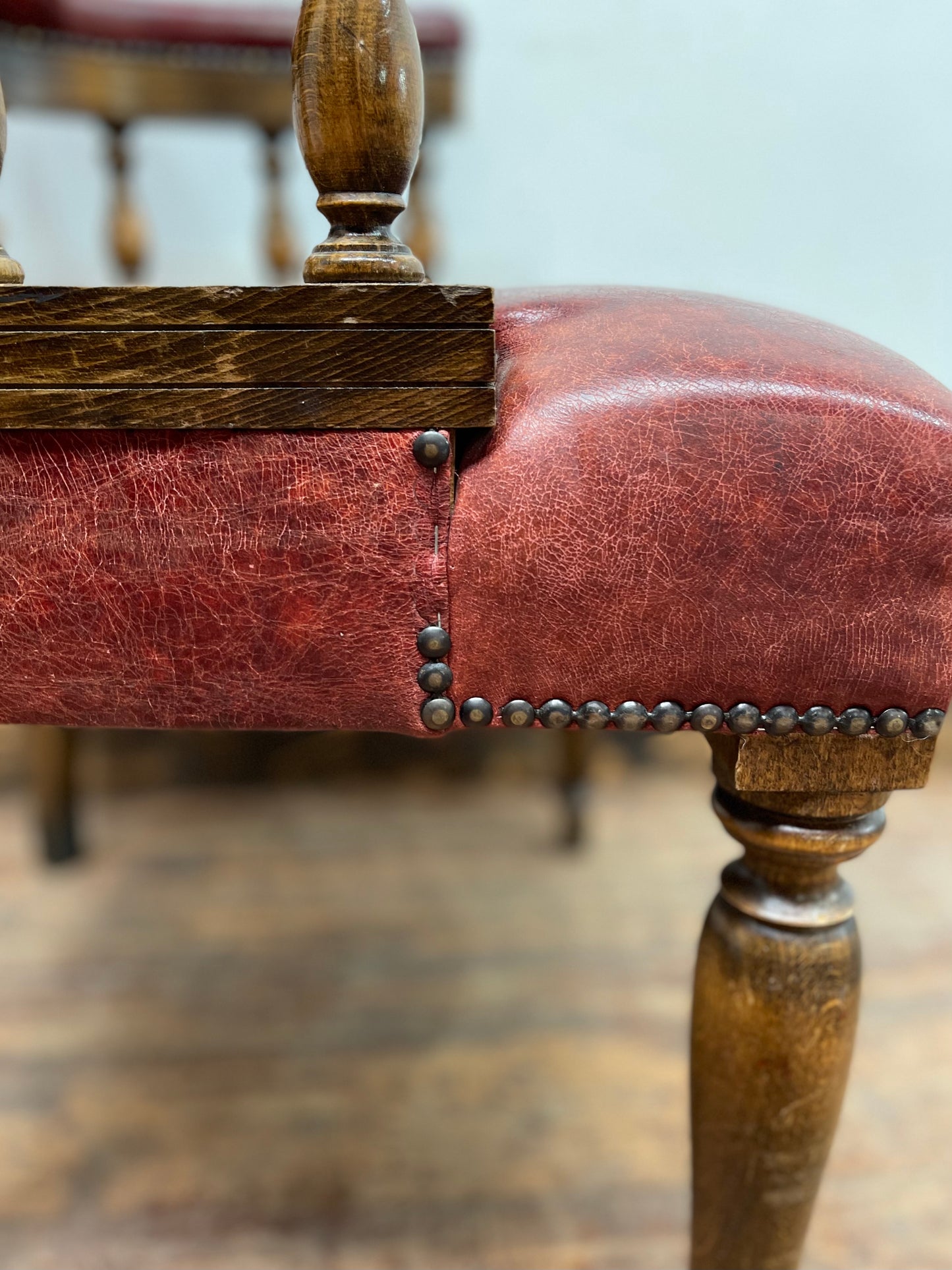 Stunning red leather captain's chair with wooden spindle back