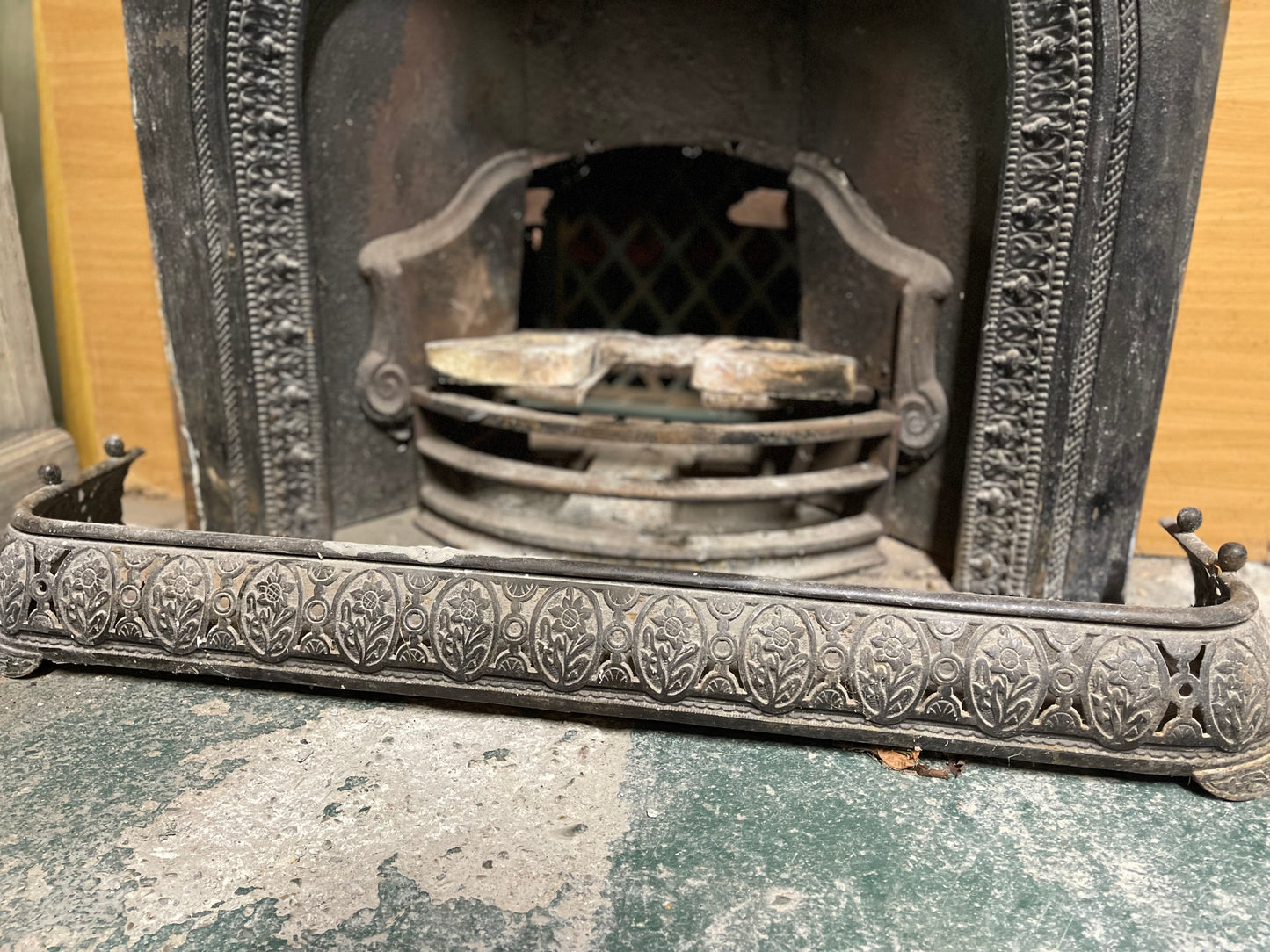 Old cast iron fireplace with decorative fender