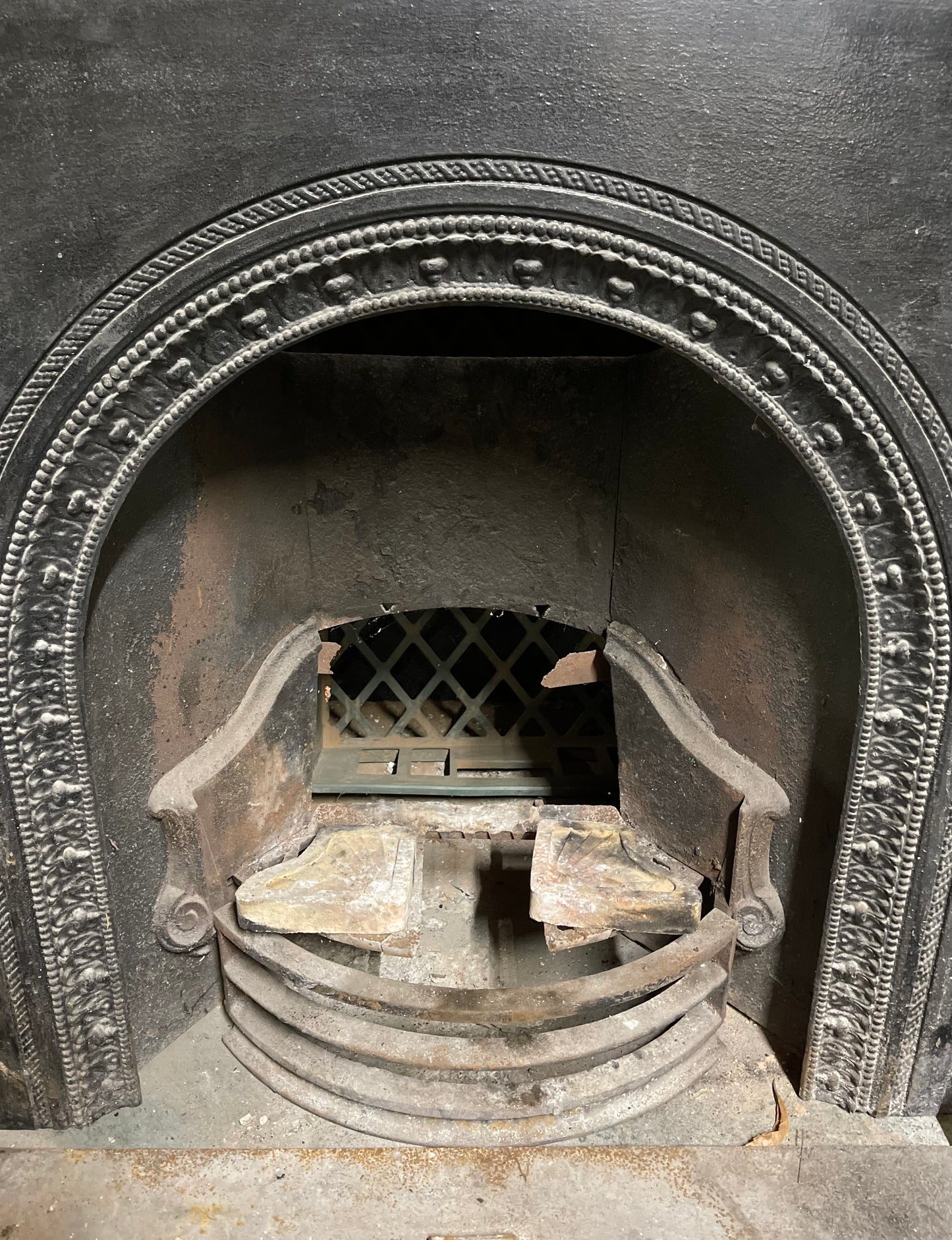 Old cast iron fireplace with decorative fender
