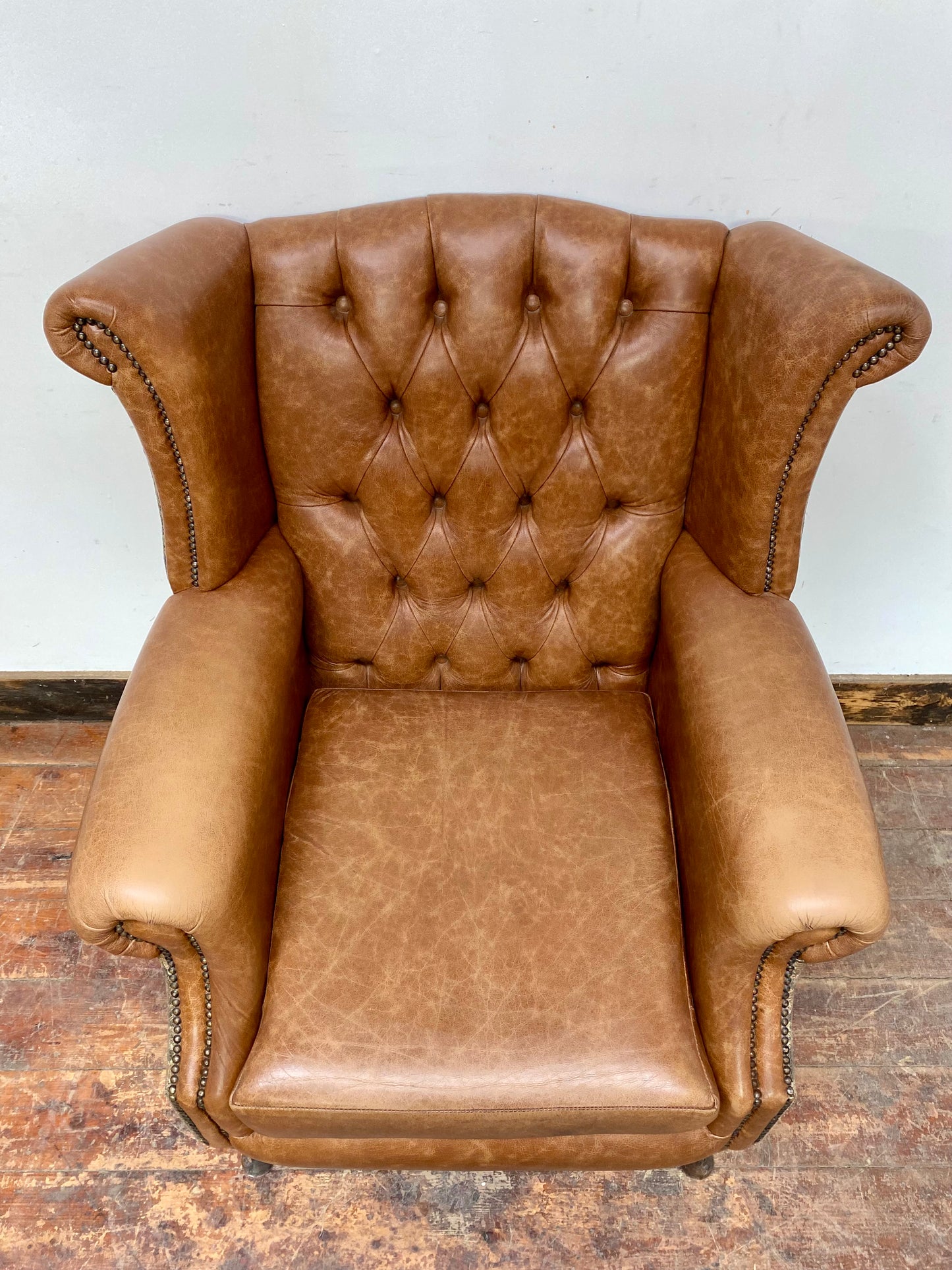 Tan leather wingback chair with patterned back