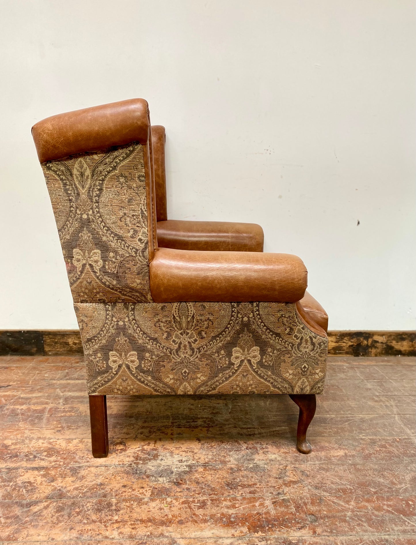 Tan leather wingback chair with patterned back