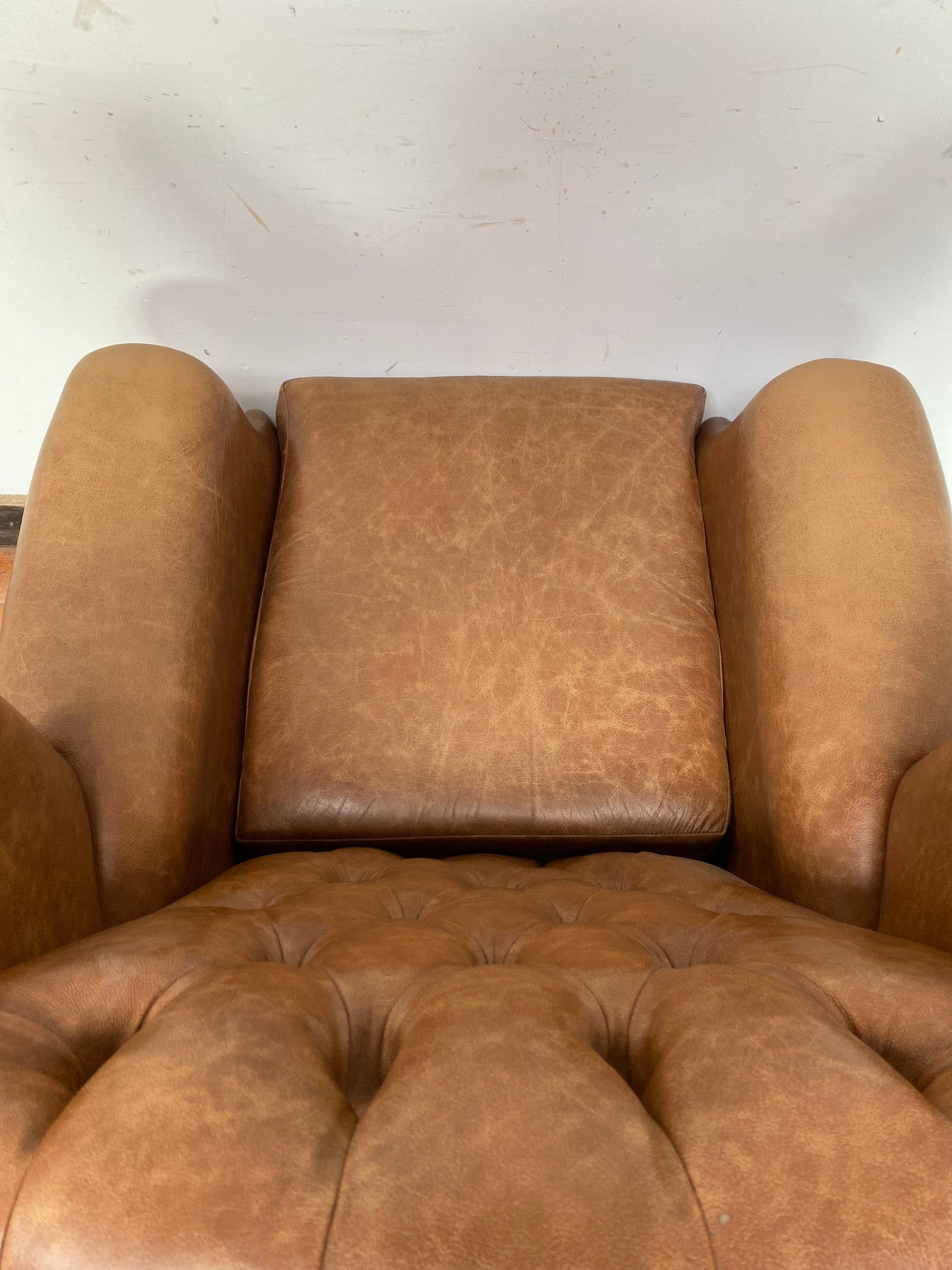 Tan leather wingback chair with patterned back