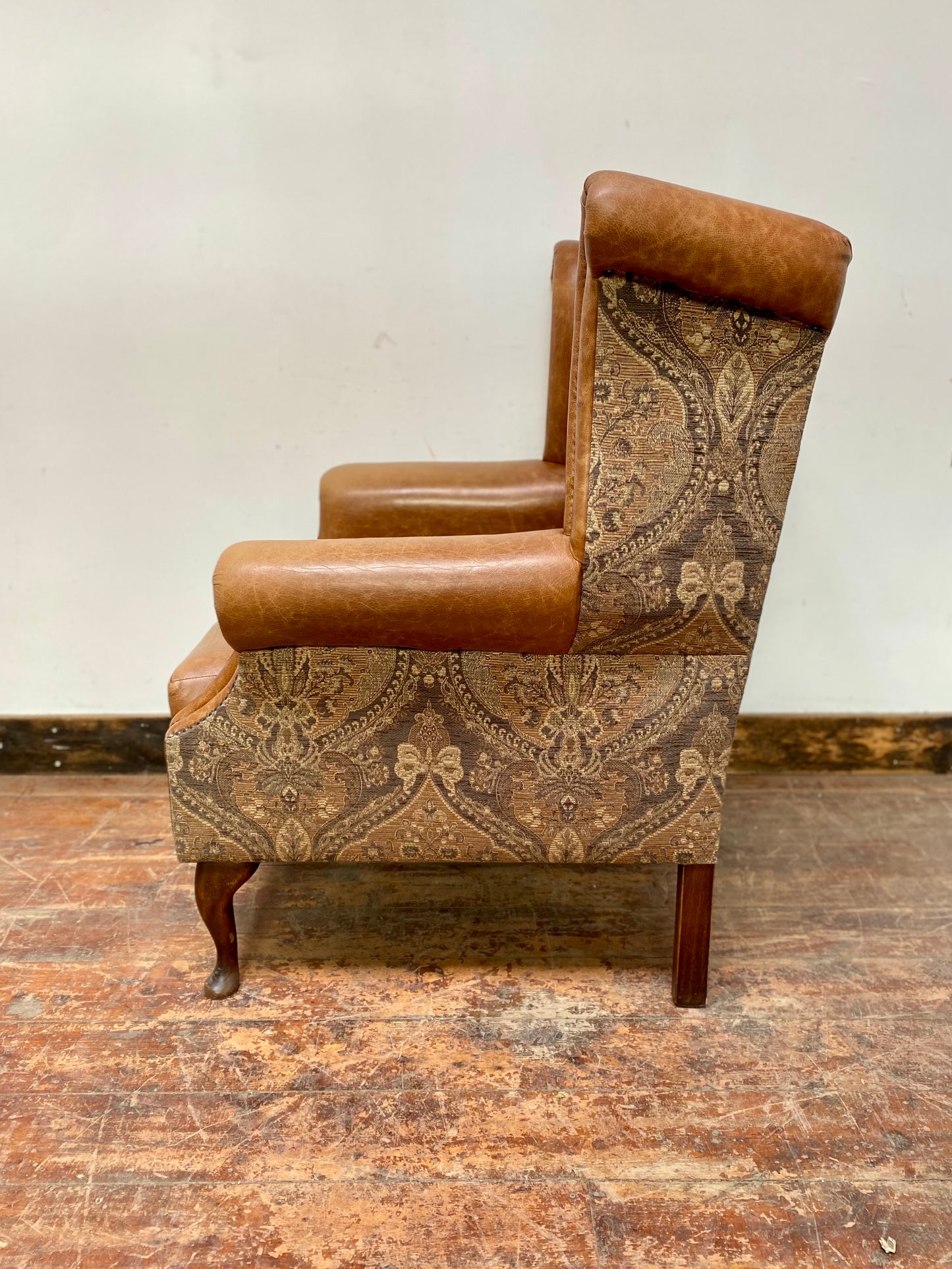 Tan leather wingback chair with patterned back