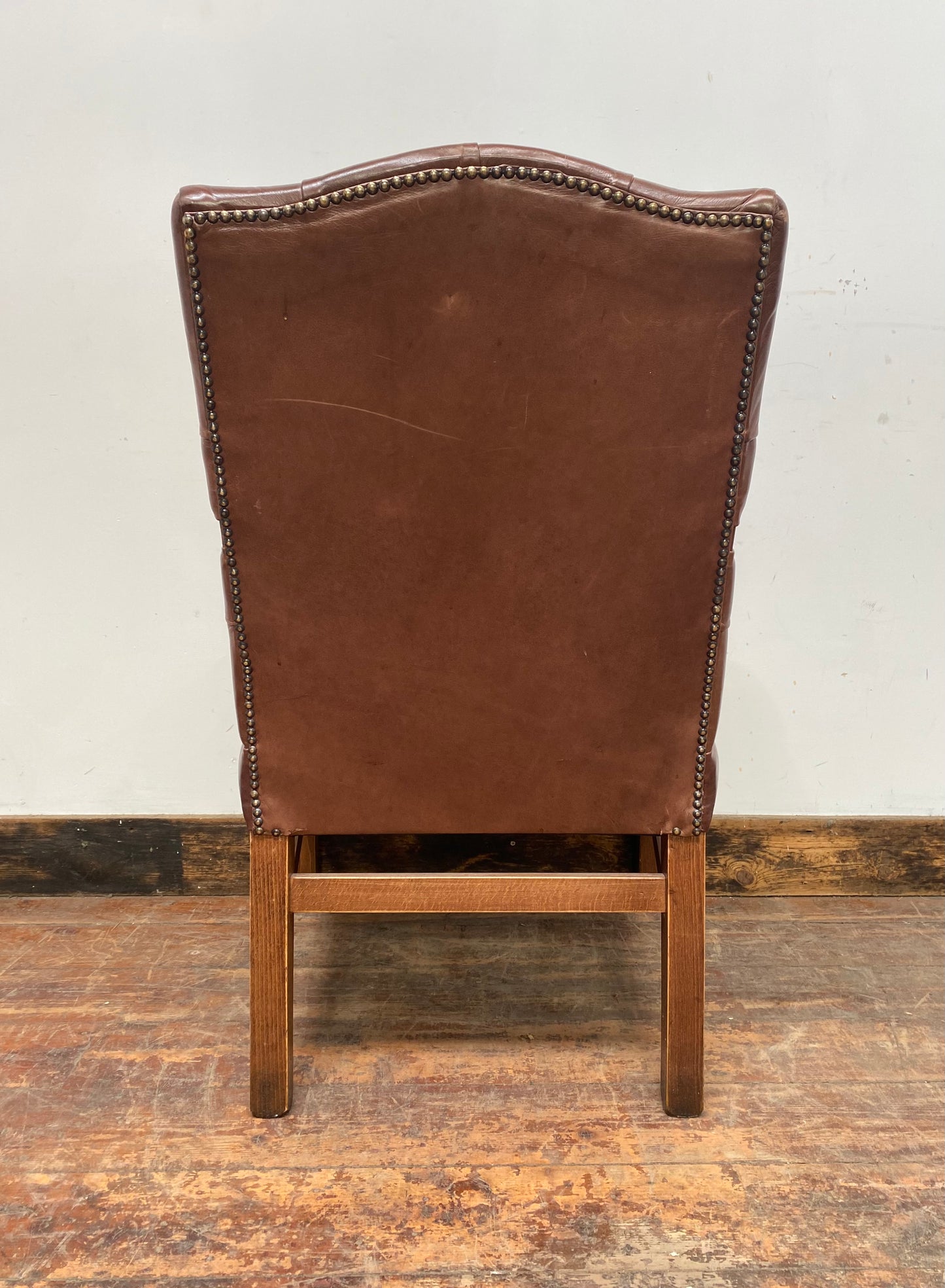 Brown leather armchair with wood frame
