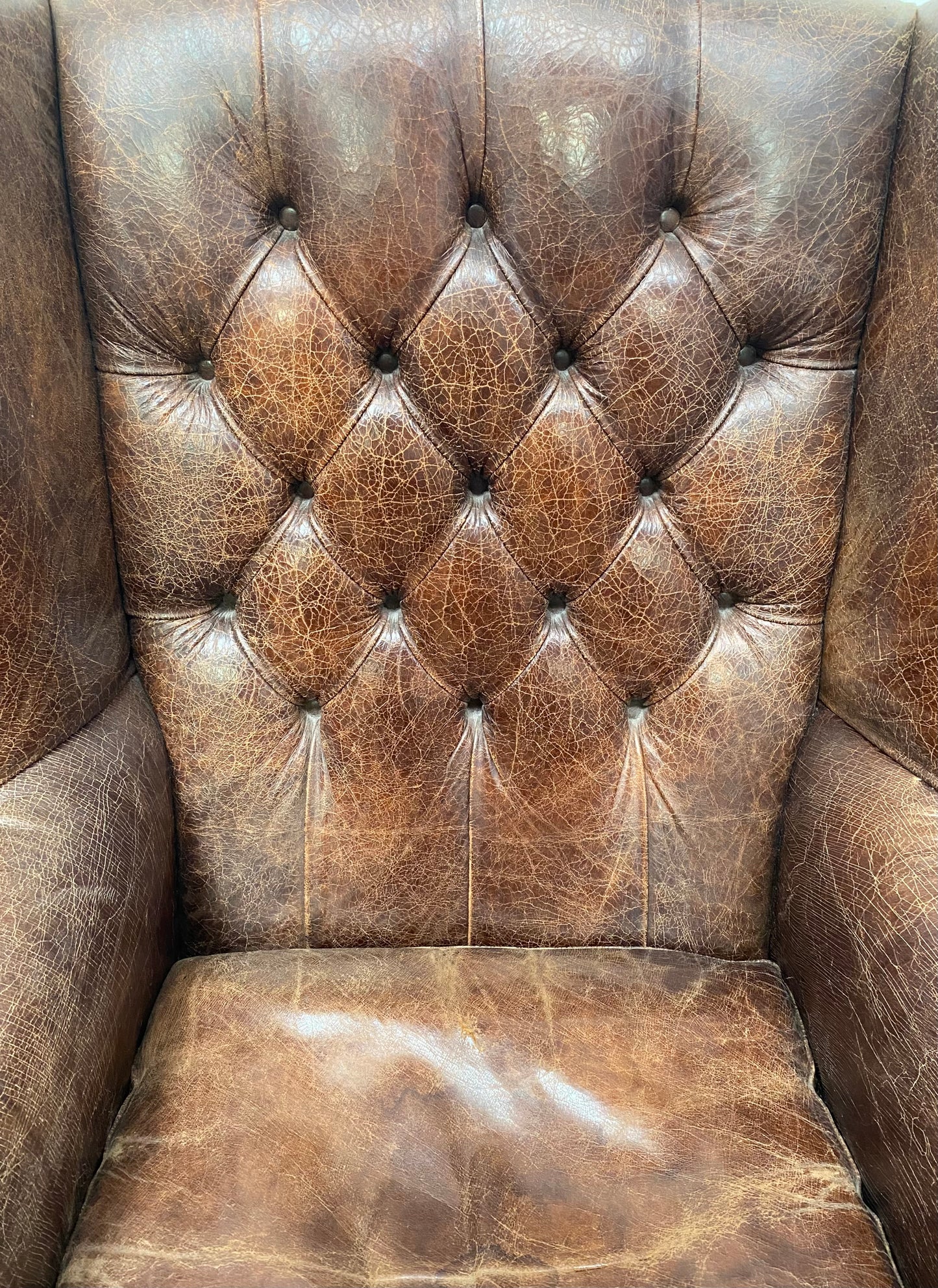 Wingback armchair in brown leather