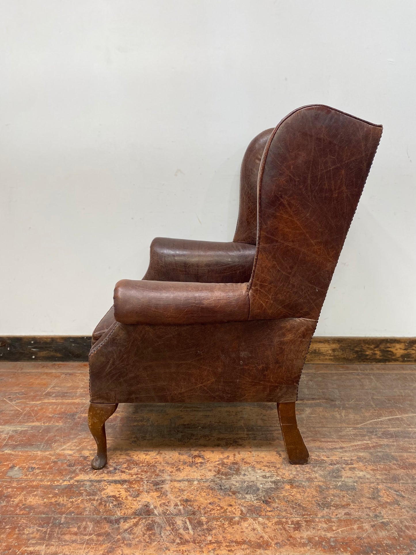 Wingback armchair in brown leather