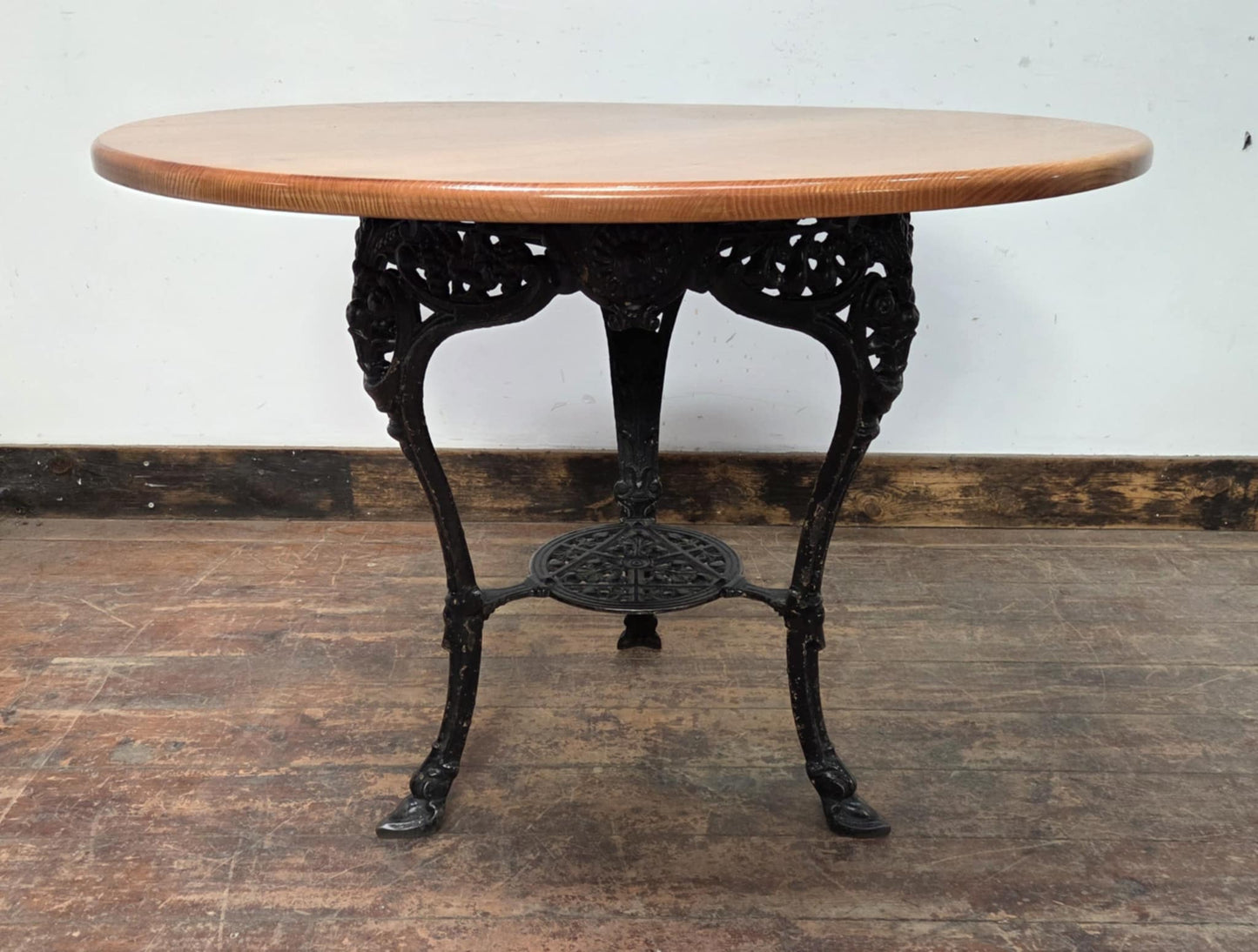 Medium Round Dining Table with Ornate Cast Iron Base and Light Wood Top