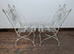 Metal Domed Patio Table and Two Chairs with Weathered Ornate Fence Design