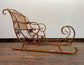 Large red and gold metal Christmas sleigh