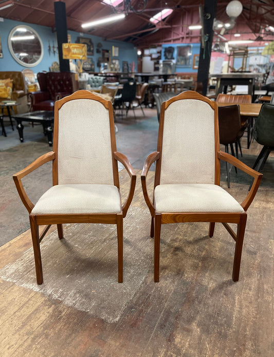 Pair of dining chairs with armrests and light fabric upholstery