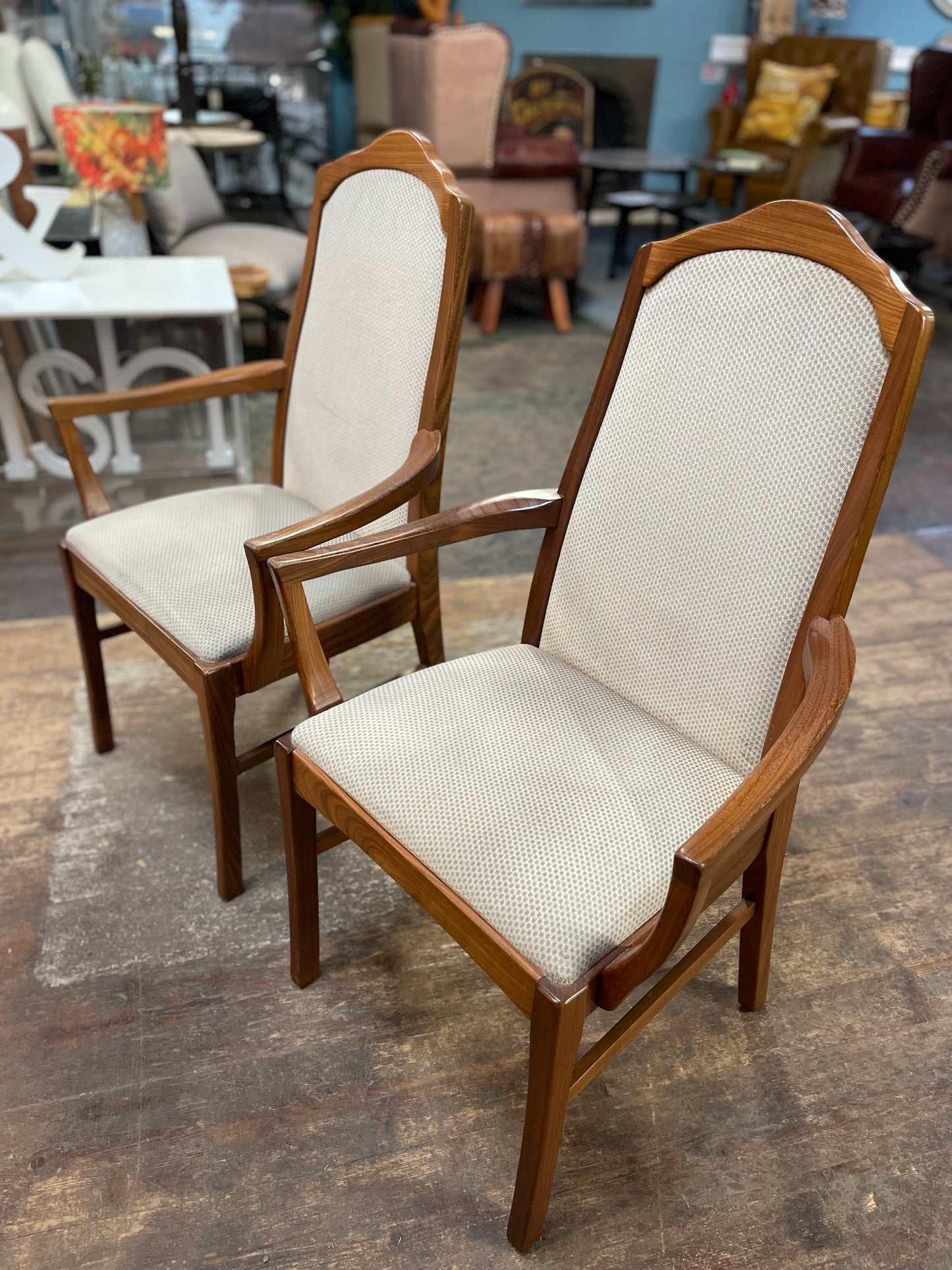 Pair of dining chairs with armrests and light fabric upholstery