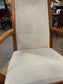 Pair of dining chairs with armrests and light fabric upholstery