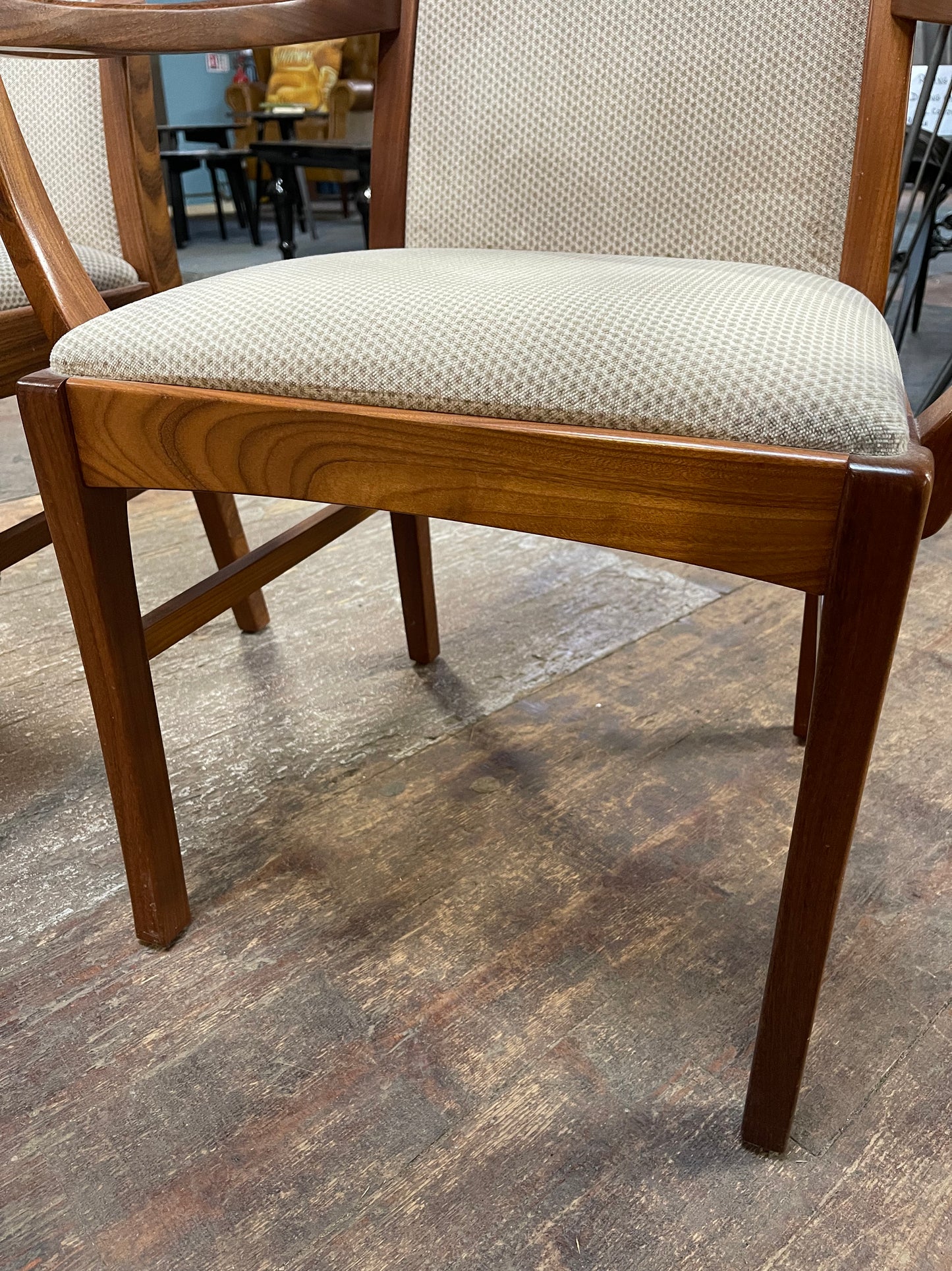 Pair of dining chairs with armrests and light fabric upholstery