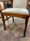 Pair of dining chairs with armrests and light fabric upholstery