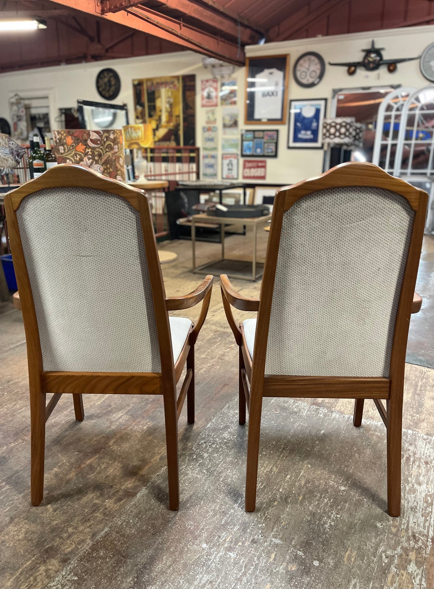 Pair of dining chairs with armrests and light fabric upholstery