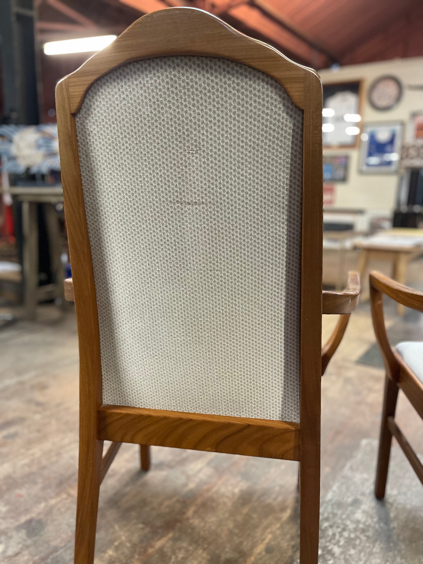 Pair of dining chairs with armrests and light fabric upholstery