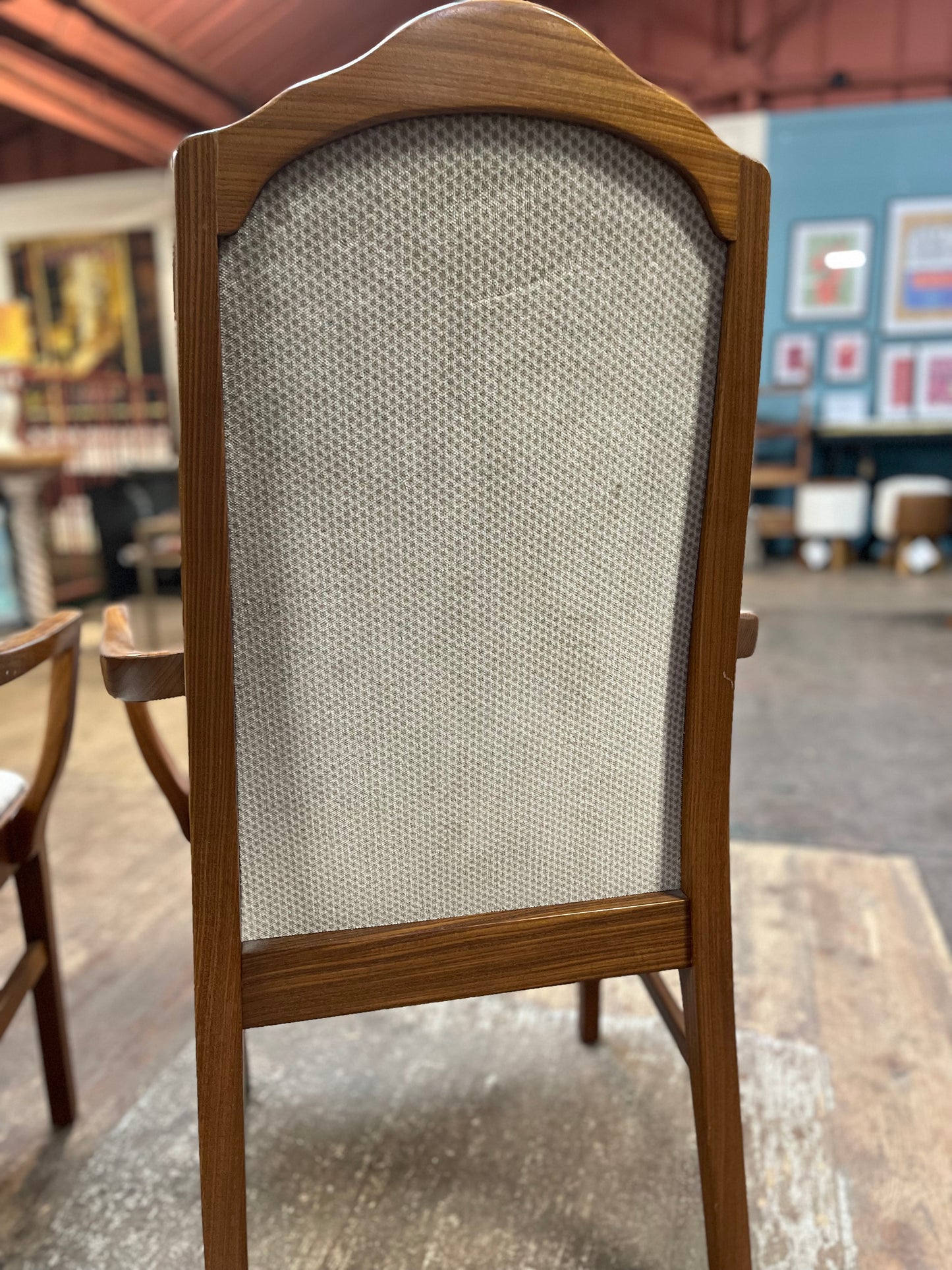 Pair of dining chairs with armrests and light fabric upholstery