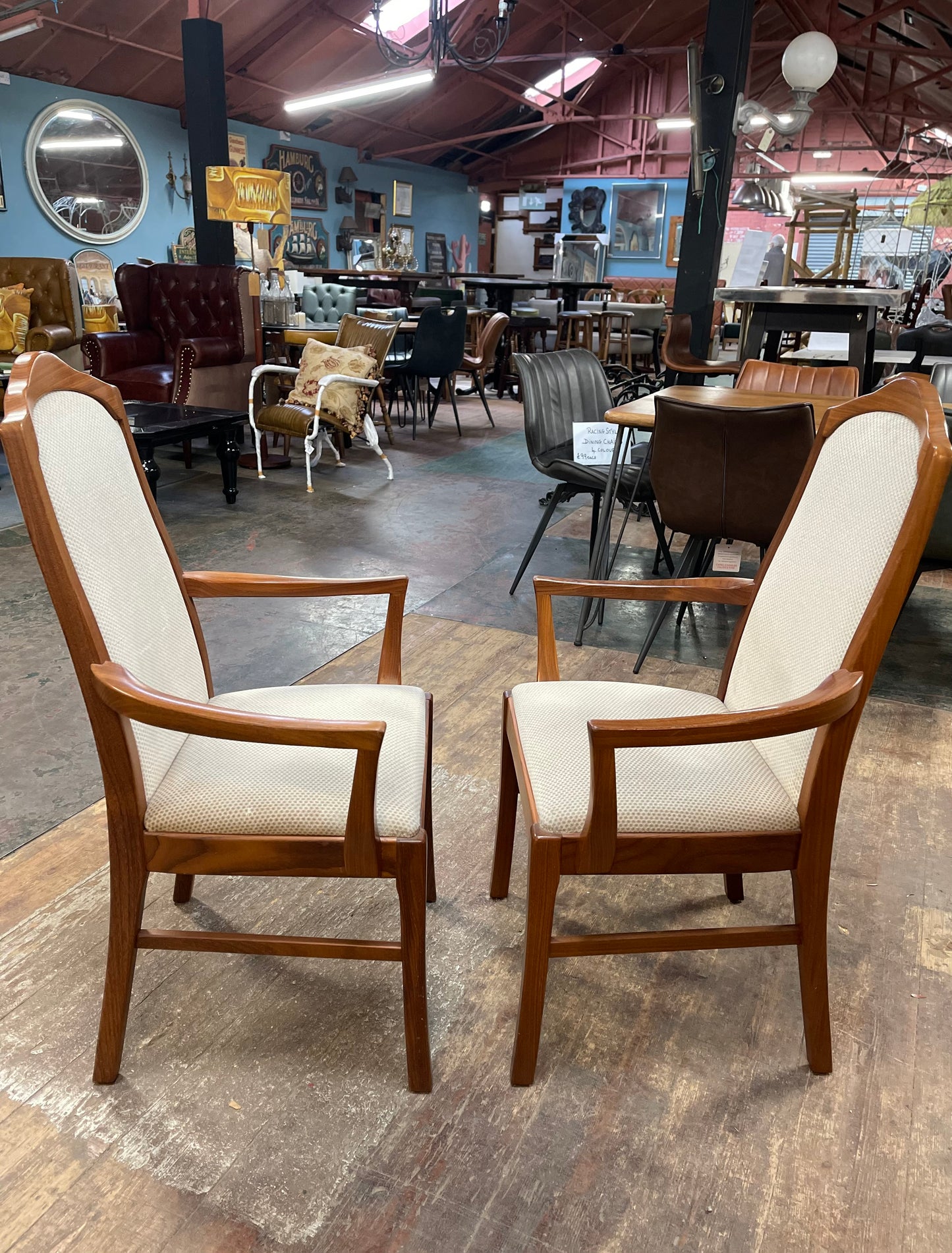 Pair of dining chairs with armrests and light fabric upholstery