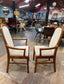 Pair of dining chairs with armrests and light fabric upholstery