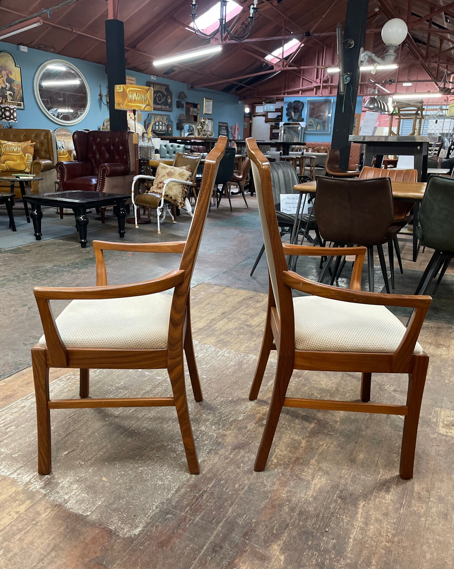Pair of dining chairs with armrests and light fabric upholstery