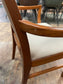 Pair of dining chairs with armrests and light fabric upholstery