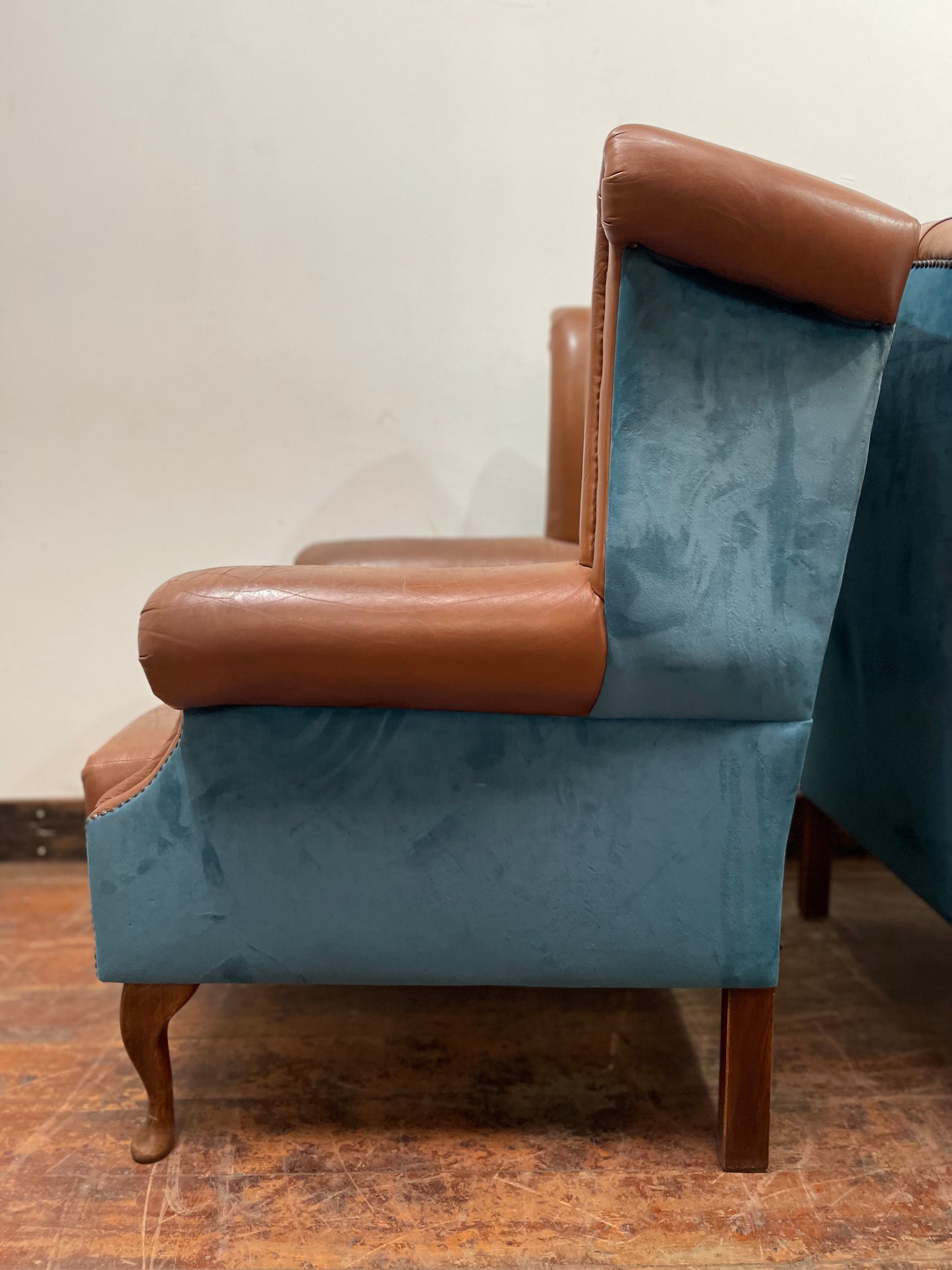 Pair of tan leather wingbacks with bright blue back and sides