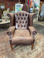 Brown leather wingback armchair with patterned fabric back and sides
