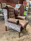 Brown leather wingback armchair with patterned fabric back and sides