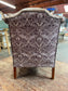 Brown leather wingback armchair with patterned fabric back and sides