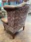 Brown leather wingback armchair with patterned fabric back and sides