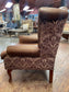 Brown leather wingback armchair with patterned fabric back and sides