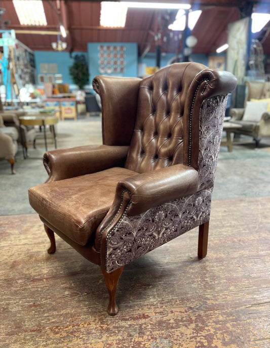 Brown leather wingback armchair with patterned fabric back and sides