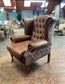 Brown leather wingback armchair with patterned fabric back and sides