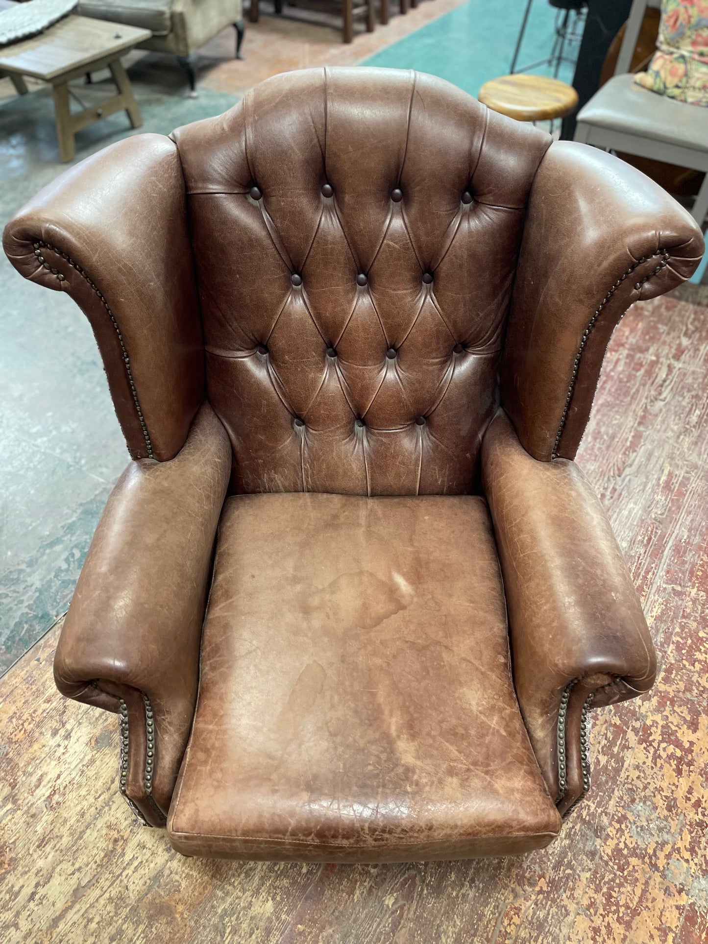 Brown leather wingback armchair with patterned fabric back and sides