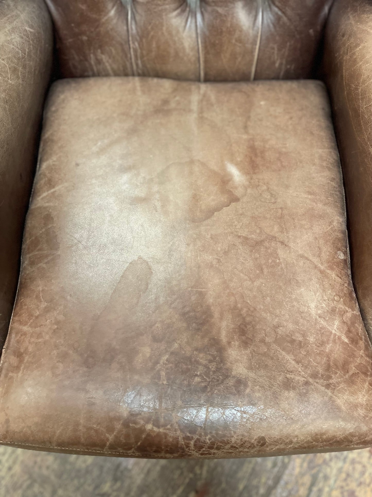 Brown leather wingback armchair with patterned fabric back and sides