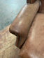 Brown leather wingback armchair with patterned fabric back and sides